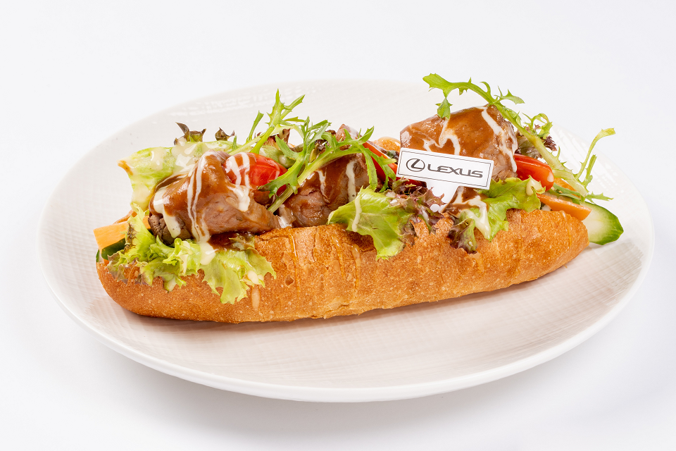 「法式燉牛肉堡」以法國長棍麵包搭配香嫩的菲力牛肉,沾上酸酸甜甜的蜂蜜芥茉醬,洋溢著美法交織的迷人風情 。