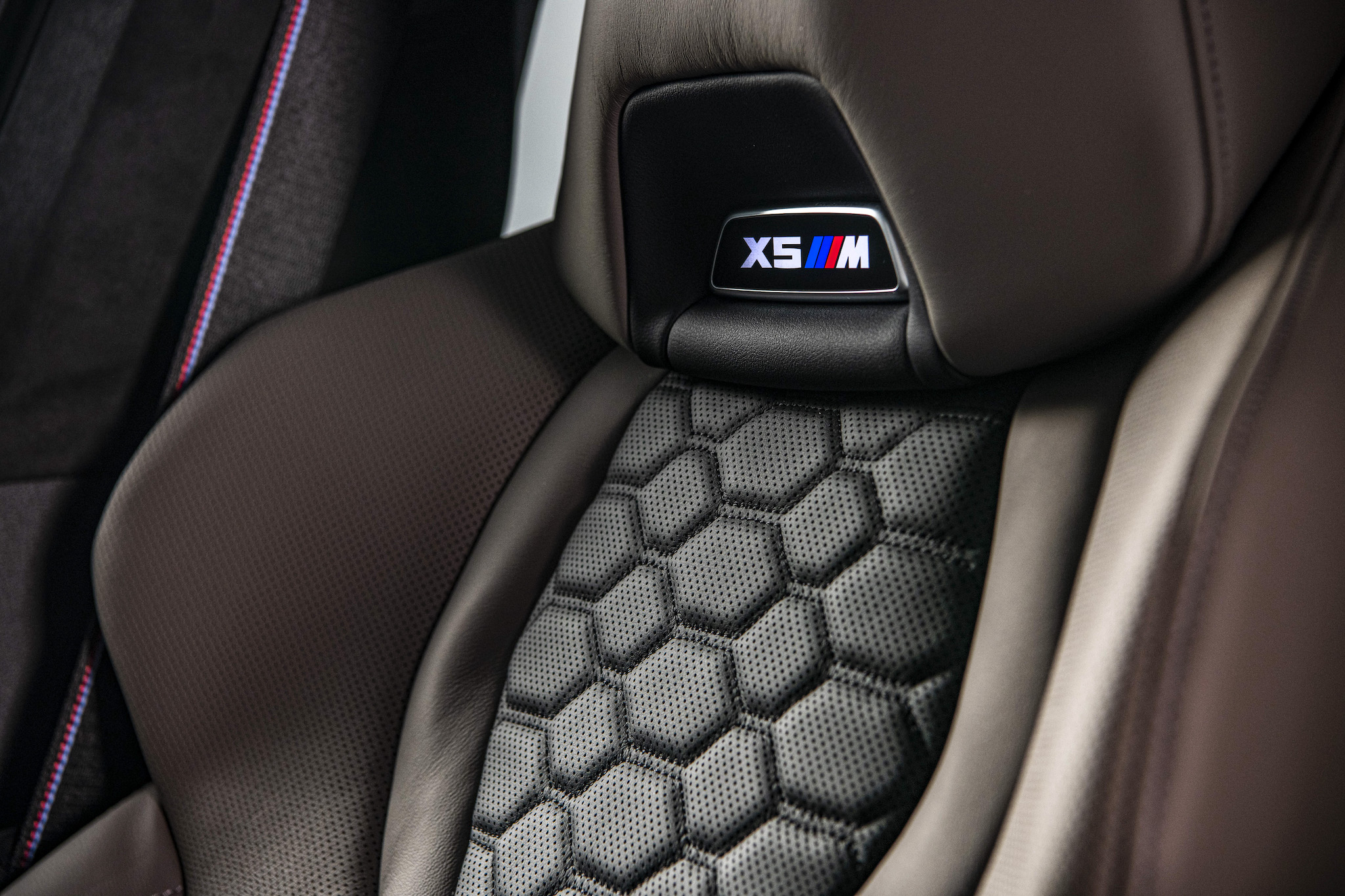 Merino 皮革 M 專屬雙前座雙色跑車座椅與發光 X5 M 銘牌。