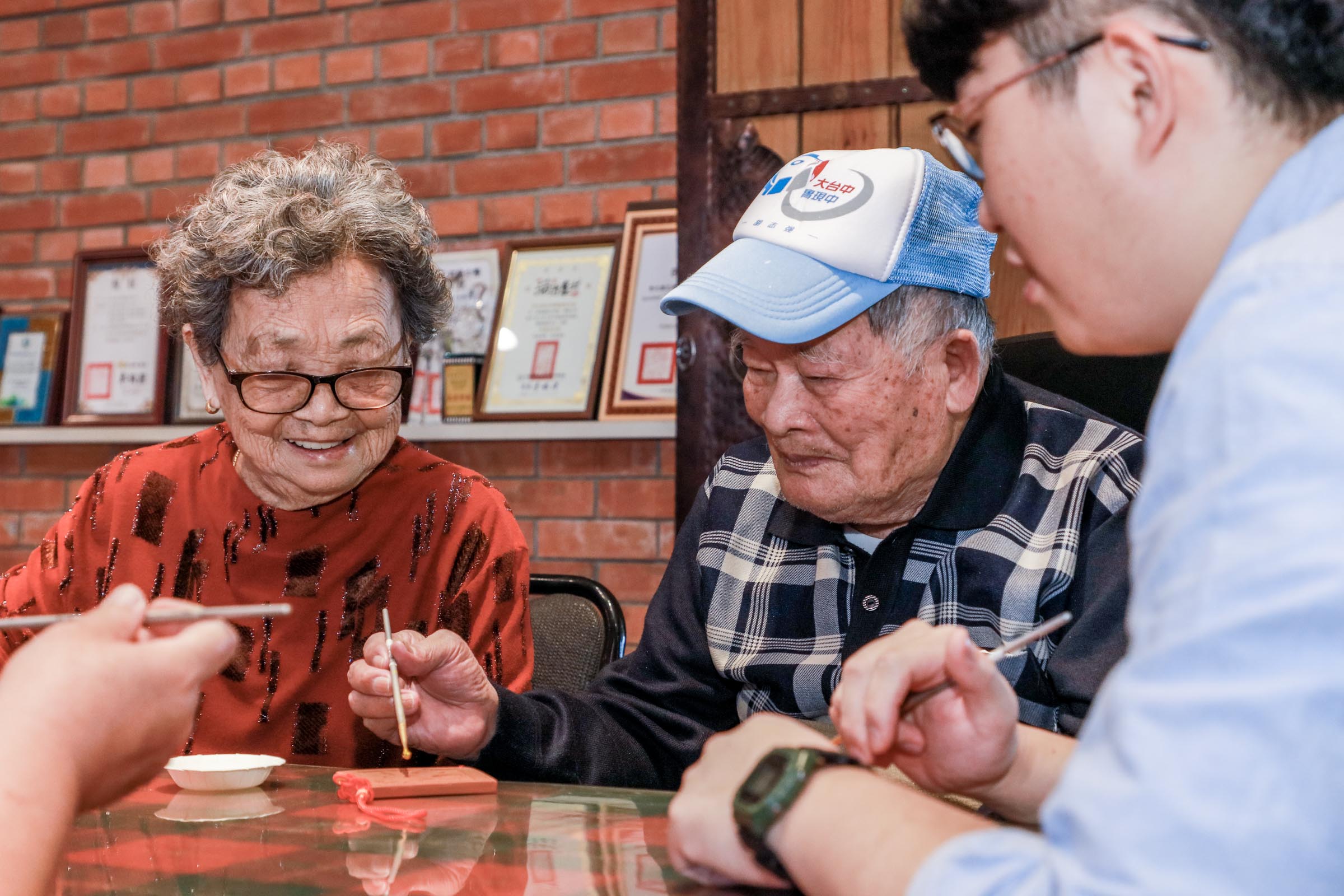 裕隆員工牽著母親的手在彰化花壇橋頭社區，體驗古早製磚風情、中國結磚瓦描金。