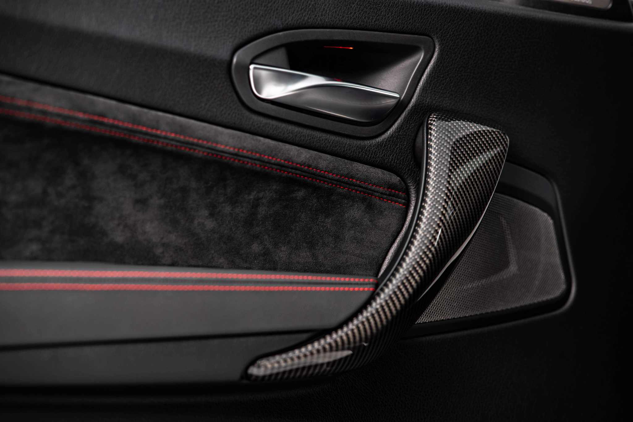 M2 CS 車內門板以柔軟麂皮包覆搭配碳纖維材質把手。