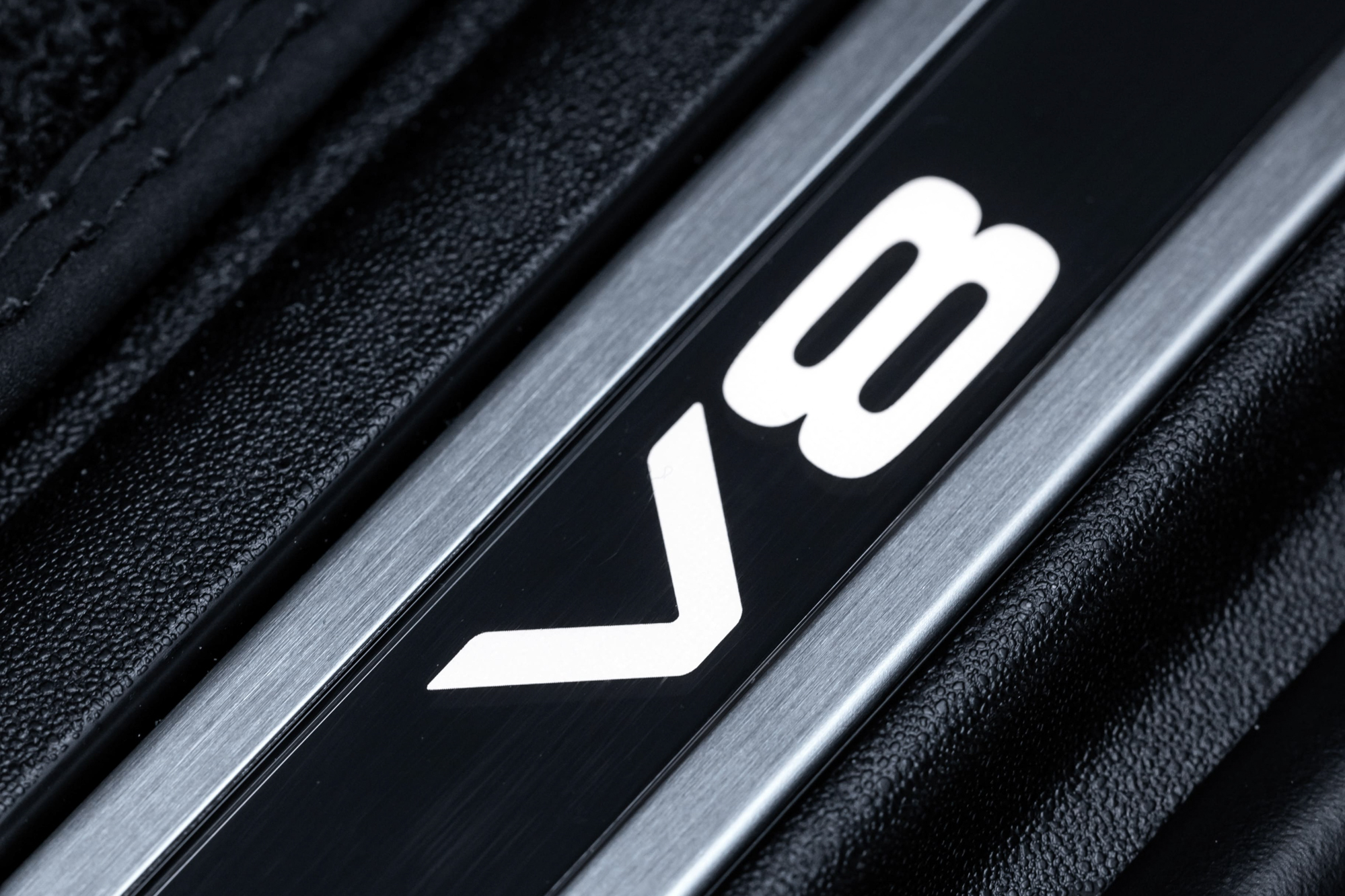 車室的發光金屬門檻上鑲嵌 V8 專屬字樣，彰顯其不凡的身分定位。