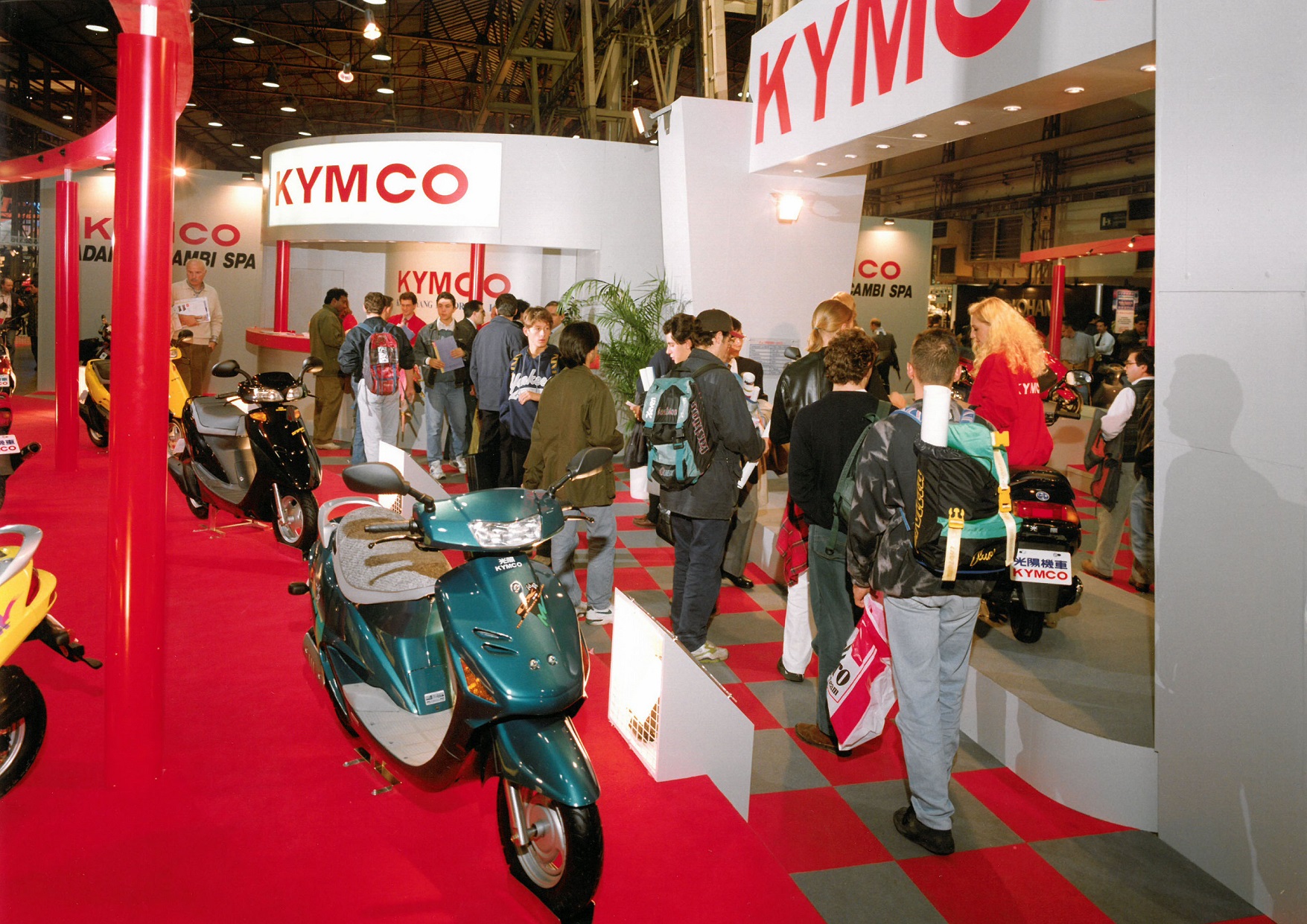 1993 年官方正式參展的攤位實景圖。1992 年，光陽與本田正式結束合作關係，改用自創的「KYMCO」品牌行銷國際迄今達108國，全球累計銷售超過千萬台 Kymco 機車。