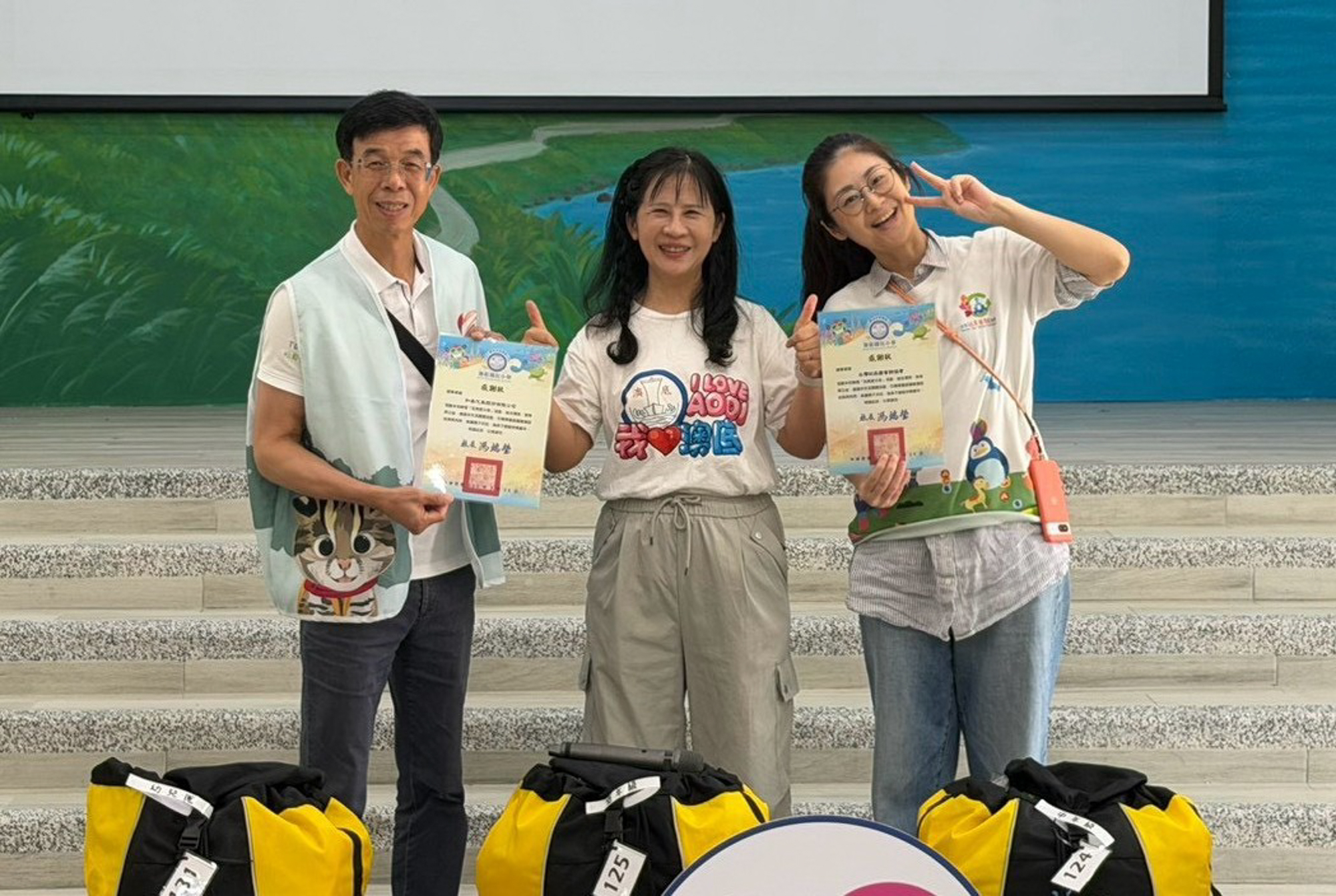 澳底國小馮端瑩校長(中)致贈感謝狀予 和泰汽車吳家炎本部長(左一)、台灣玩具圖書館協會張維庭秘書長(右一)。
