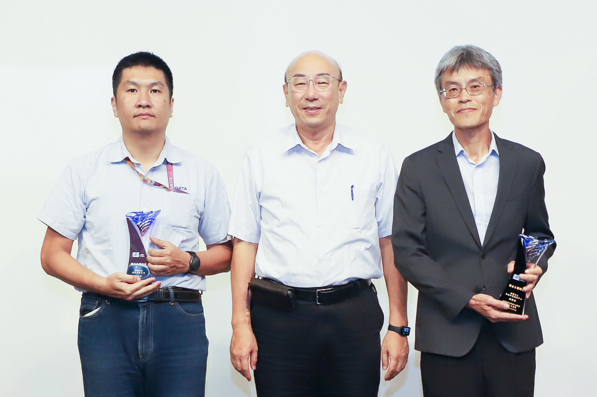 車輛中心陳偉霖經理（右1）及威剛科技閻柏均經理（左1）獲得傑出工程師獎，獎項由台灣大學教授劉霆（中）頒發合影。