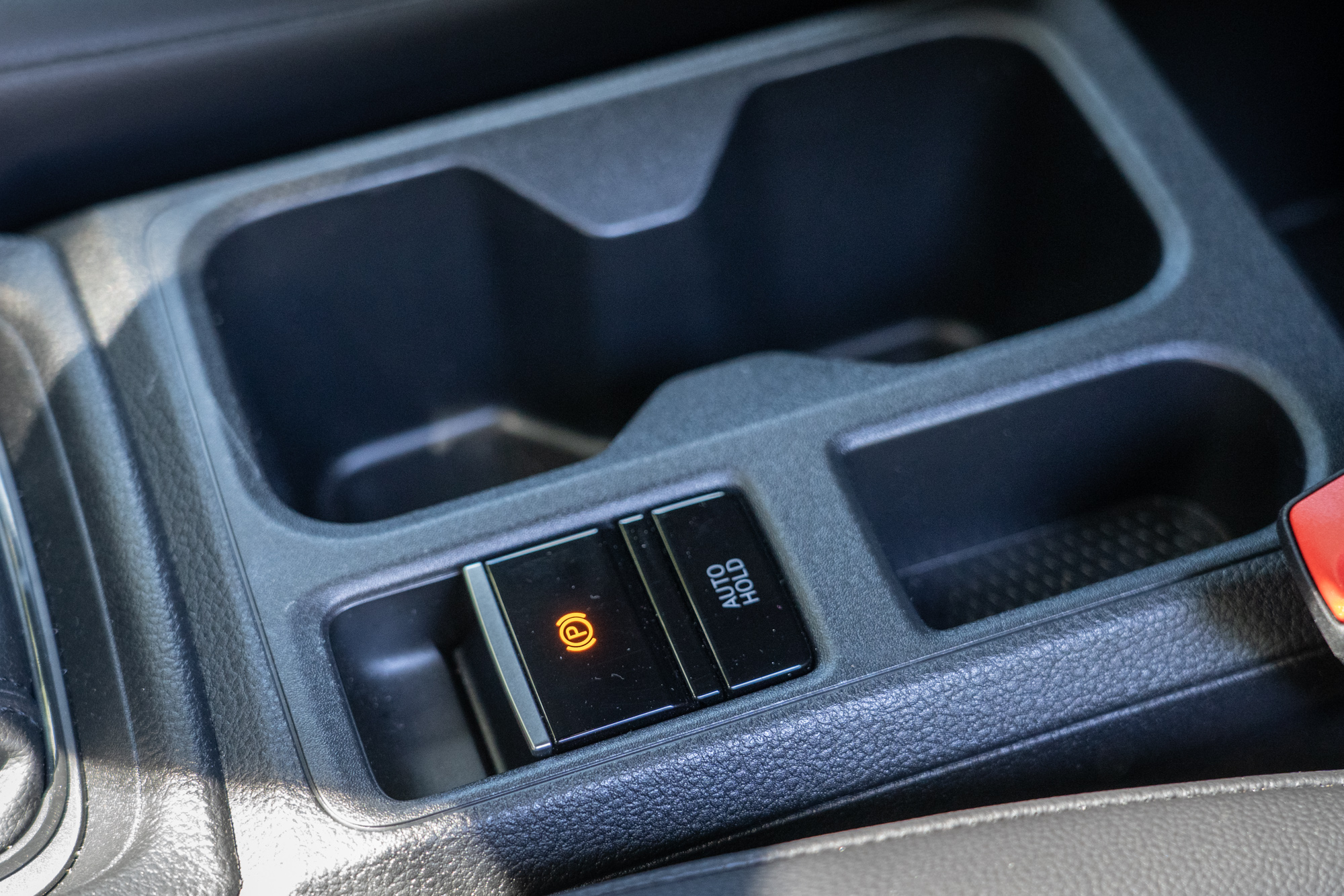 排檔座後方的置杯架與小置物空間，並有電子手煞車含 Auto Hold 車輛靜止功能。